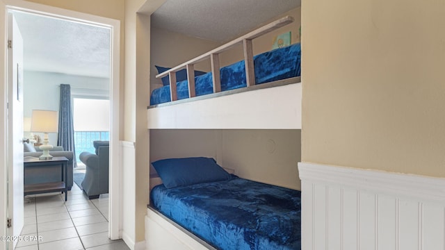 bedroom featuring tile patterned flooring and a textured ceiling