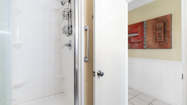 bathroom featuring tile patterned floors and a shower with shower door