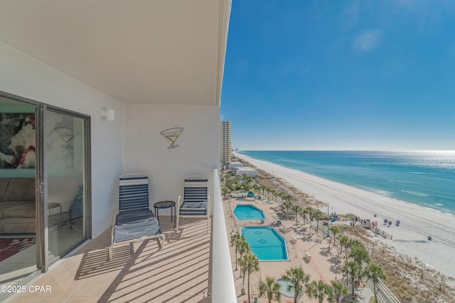 balcony featuring a view of the beach and a water view