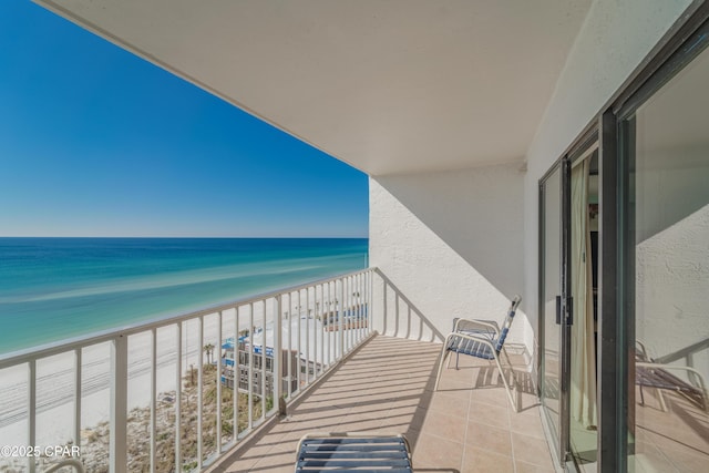 balcony with a water view and a view of the beach