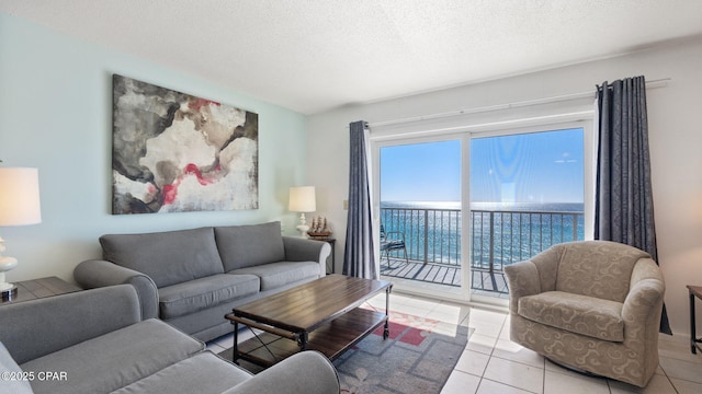 living room featuring light tile patterned flooring, a water view, and a textured ceiling