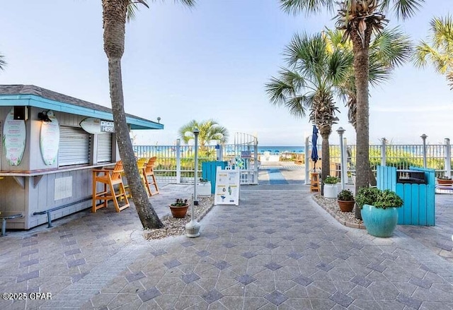 view of patio with a water view and exterior bar