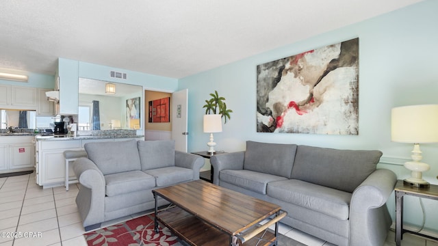 living room featuring light tile patterned flooring and a textured ceiling