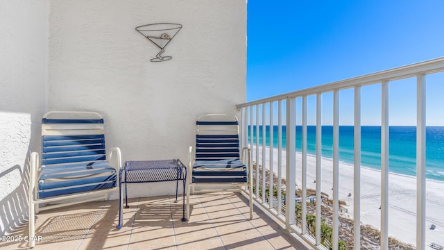 balcony featuring a water view and a beach view