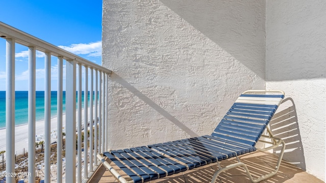 balcony featuring a water view and a beach view