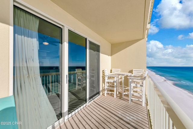 balcony with a water view and a view of the beach