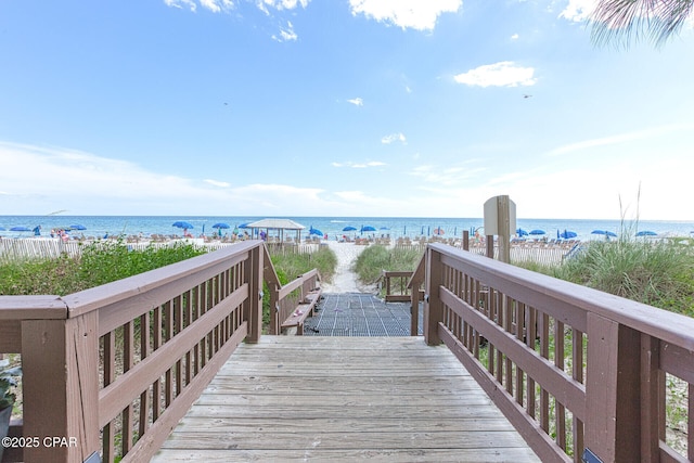 view of property's community featuring a water view and a beach view