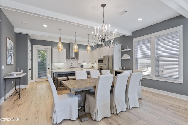 dining room featuring beamed ceiling, sink, an inviting chandelier, and light wood-type flooring