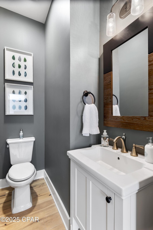 bathroom featuring vanity, toilet, and hardwood / wood-style floors