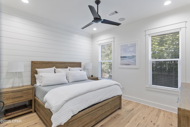 bedroom with light hardwood / wood-style flooring, ornamental molding, and ceiling fan