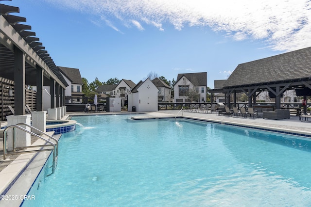 view of pool with a hot tub and a patio