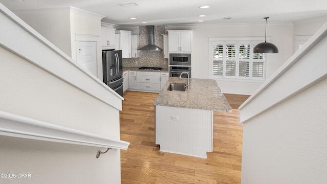 kitchen featuring wall chimney exhaust hood, stainless steel appliances, a breakfast bar, and white cabinets