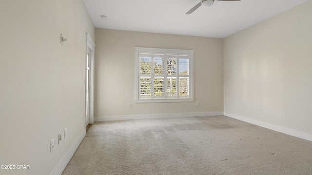 spare room featuring light carpet and ceiling fan