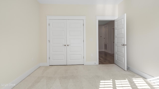 unfurnished bedroom featuring light colored carpet and a closet