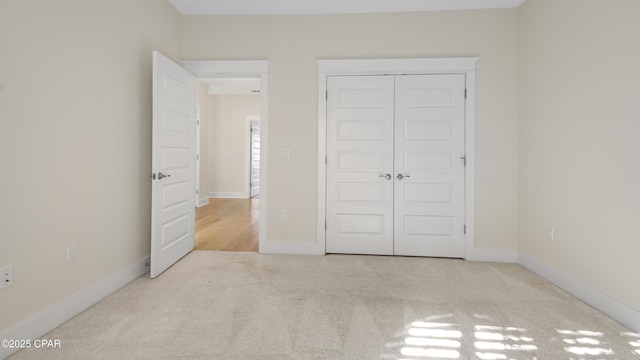 unfurnished bedroom featuring light colored carpet and a closet