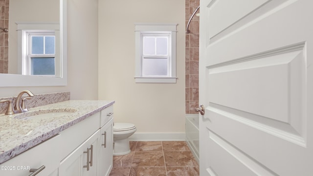 full bathroom featuring vanity, tiled shower / bath, and toilet