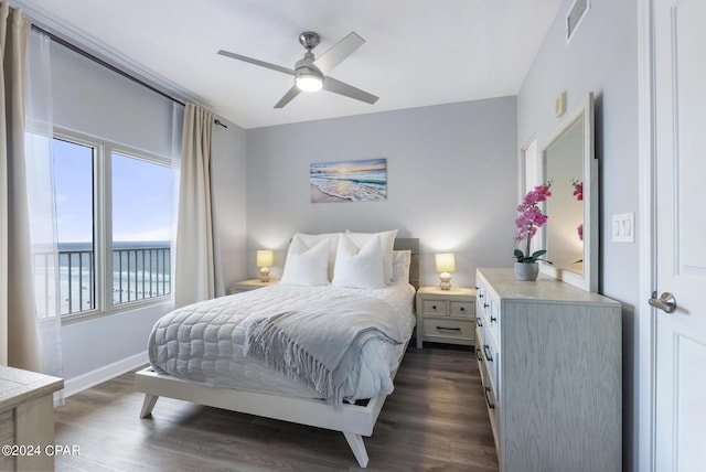 bedroom featuring a water view, dark wood-type flooring, and ceiling fan