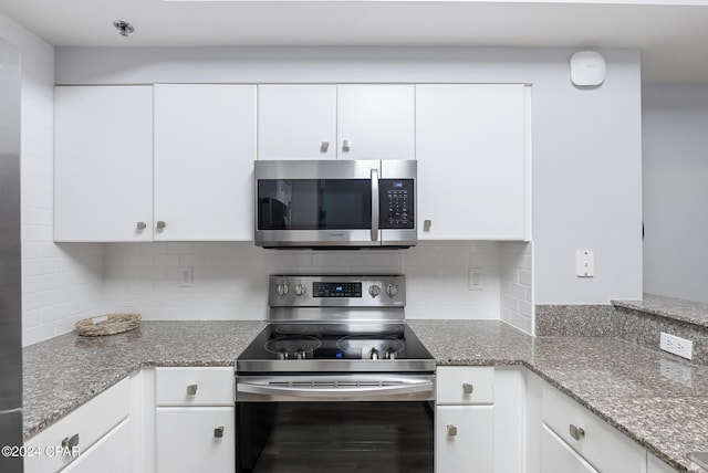 kitchen with decorative backsplash, appliances with stainless steel finishes, and white cabinetry