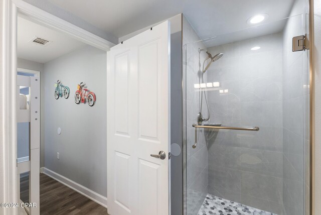 bathroom with wood-type flooring and an enclosed shower