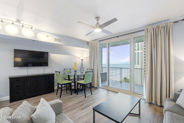 living room featuring a water view, ceiling fan, and light hardwood / wood-style flooring