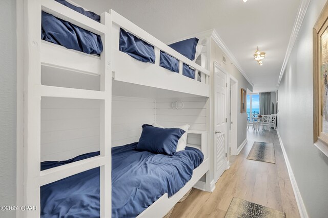 bedroom featuring crown molding and light wood-type flooring