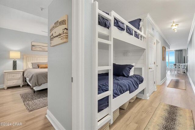 bedroom featuring light wood-type flooring and crown molding