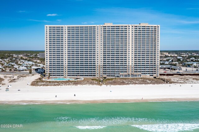 view of building exterior with a water view and a beach view