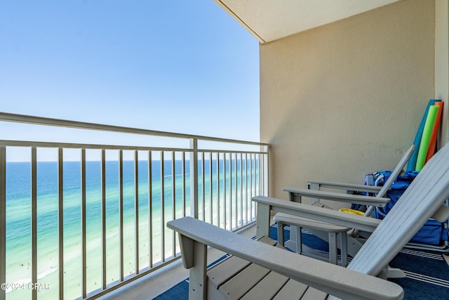 balcony with a water view and a view of the beach