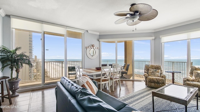 sunroom featuring a water view and ceiling fan