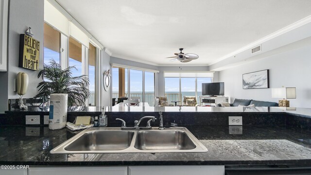 kitchen with sink, white cabinetry, crown molding, dishwashing machine, and ceiling fan