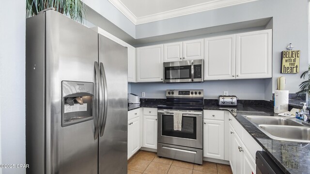 kitchen with sink, light tile patterned floors, stainless steel appliances, ornamental molding, and white cabinets