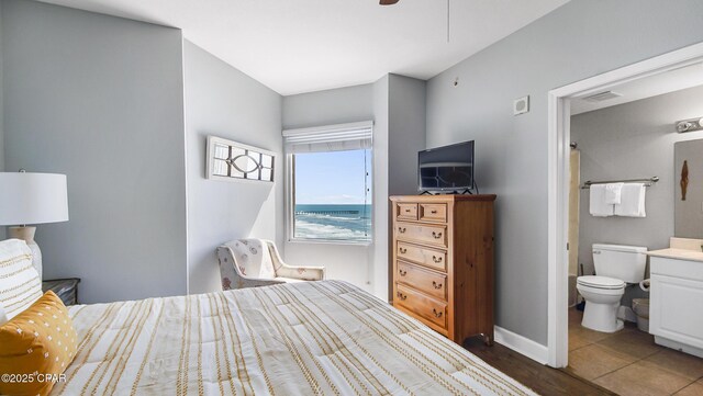 bedroom featuring ensuite bath and ceiling fan