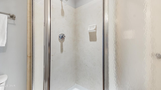 bathroom with an enclosed shower and toilet