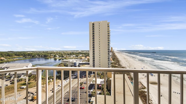 balcony with a water view and a view of the beach