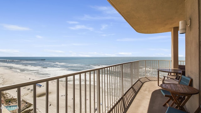 balcony featuring a water view and a view of the beach