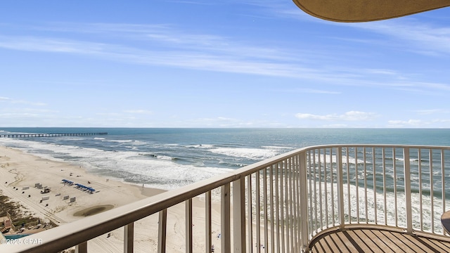 balcony featuring a water view and a view of the beach