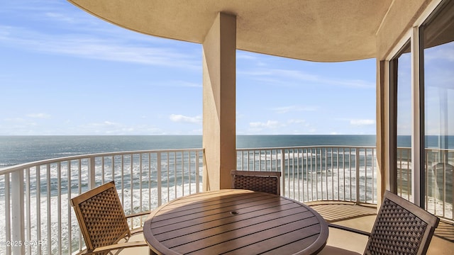 balcony featuring a water view and a beach view