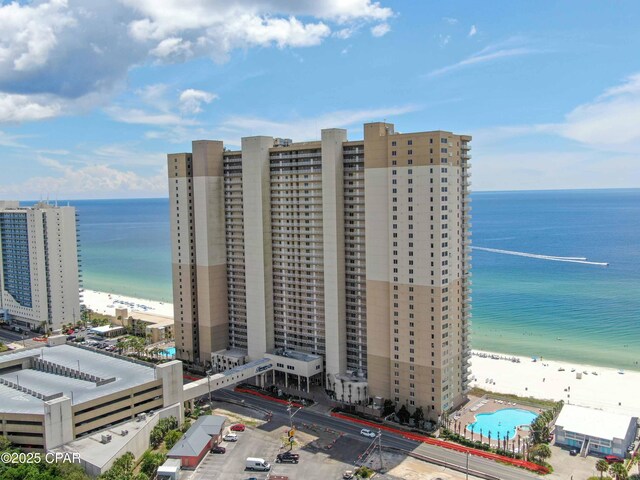 birds eye view of property with a water view and a beach view