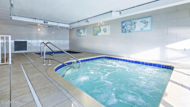 view of swimming pool featuring an indoor hot tub