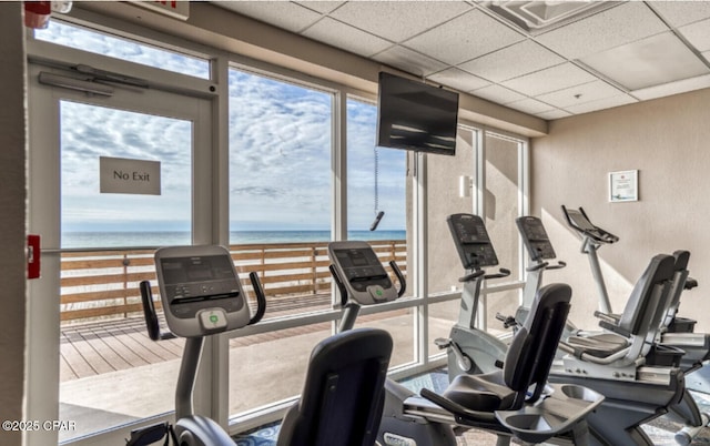 exercise room featuring a drop ceiling and a wealth of natural light