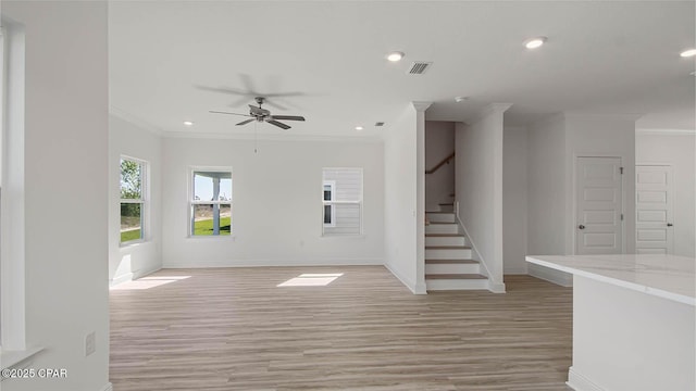 unfurnished living room with ornamental molding, recessed lighting, visible vents, and stairway