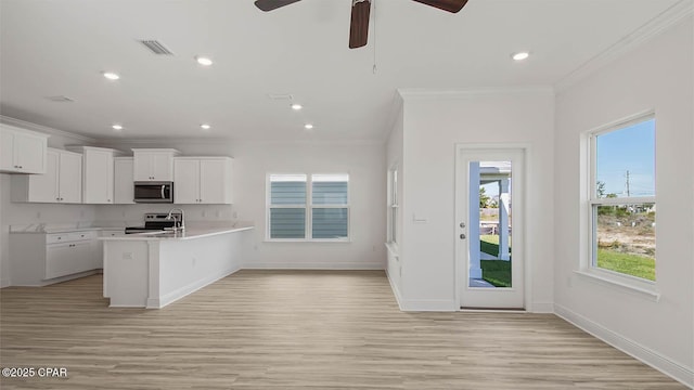 kitchen featuring visible vents, appliances with stainless steel finishes, light countertops, crown molding, and white cabinetry