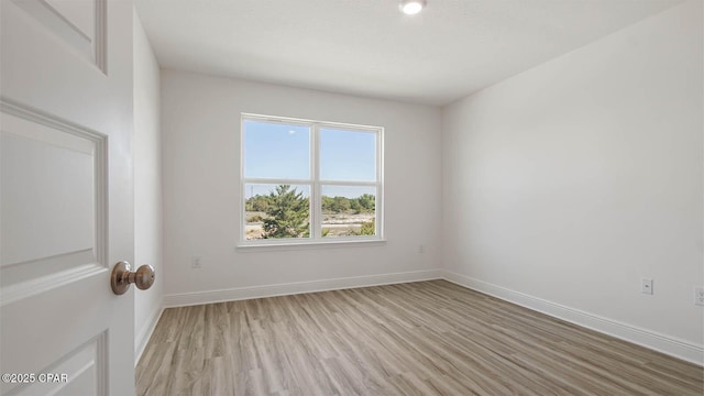 empty room featuring light wood-style floors and baseboards