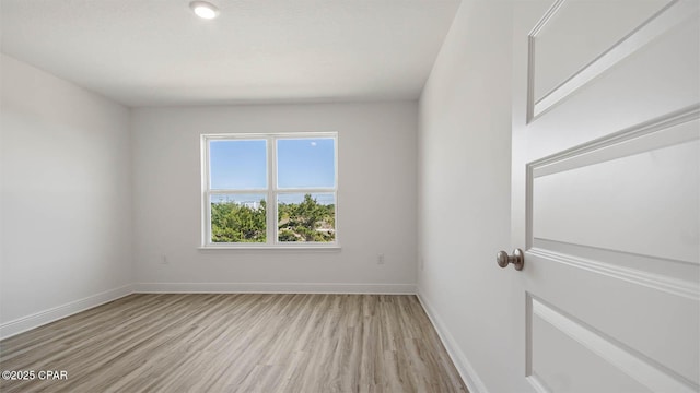 unfurnished room featuring light wood-type flooring and baseboards