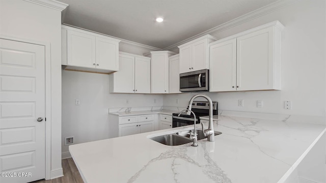 kitchen with a peninsula, light stone countertops, white cabinets, and stainless steel appliances