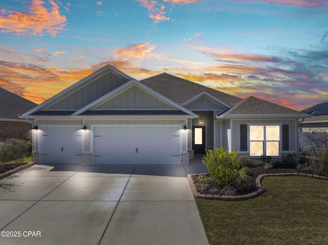 view of front of home featuring a shingled roof, concrete driveway, an attached garage, a yard, and board and batten siding