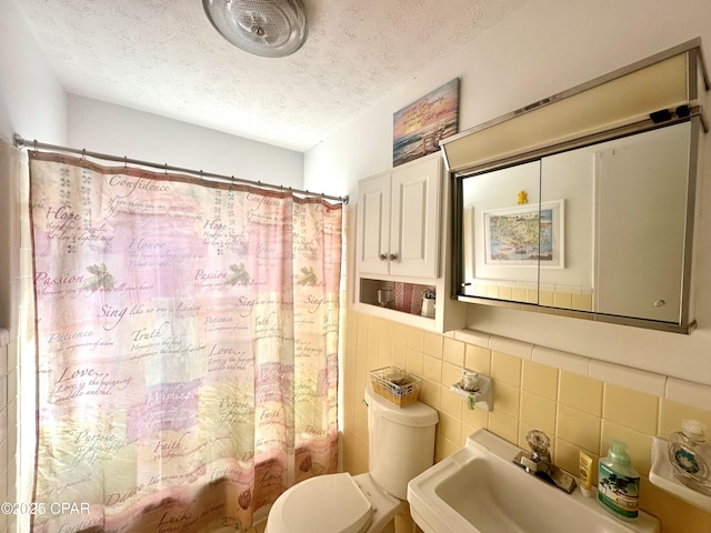 full bathroom featuring toilet, sink, tasteful backsplash, shower / tub combo, and a textured ceiling