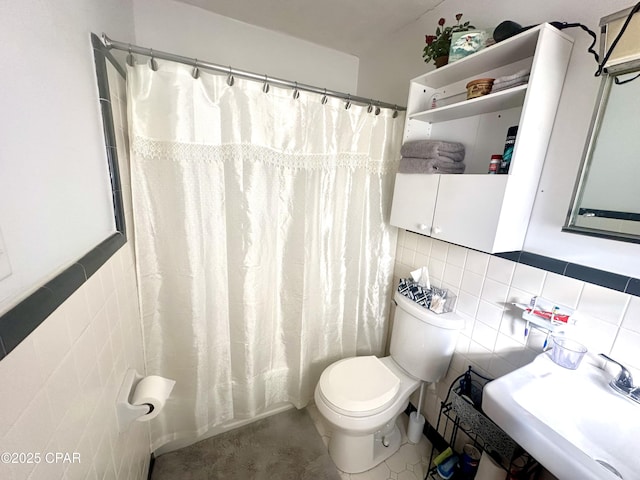 bathroom featuring toilet, sink, tile walls, and decorative backsplash