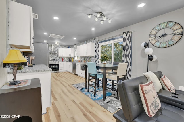 dining space with sink and light hardwood / wood-style flooring