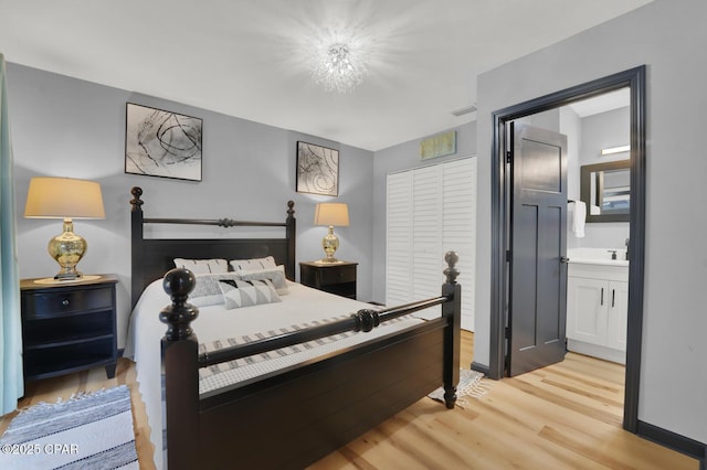 bedroom featuring connected bathroom and light wood-type flooring